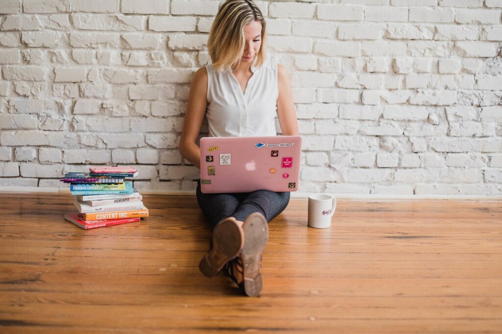 Mujer sentada en el suelo trabajando en marketing digital y marketing de contenidos